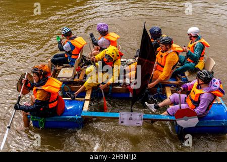 Local People In Home Made Rafts Float Down The River Ouse During The Annual Lewes To Newhaven Raft Race, Lewes, Sussex, UK. Stock Photo