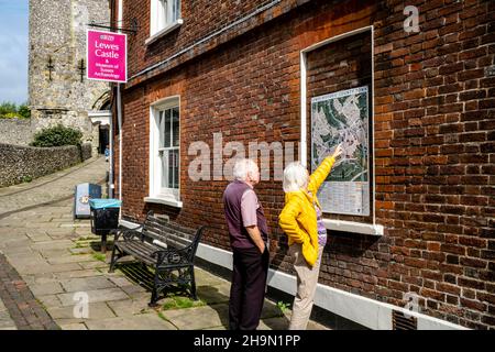 Visitors To Lewes Look At The Town Map Outside The Castle, Lewes, East Sussex, UK. Stock Photo
