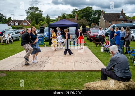 A Man Eats An Ice Cream Whilst Watching Local People Dancing At The Nutley Village Fete, Nutley, East Sussex, UK. Stock Photo