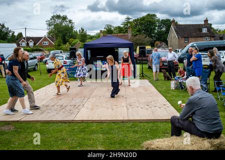 A Man Eats An Ice Cream Whilst Watching Local People Dancing At The Nutley Village Fete, Nutley, East Sussex, UK. Stock Photo