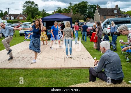 A Man Eats An Ice Cream Whilst Watching Local People Dancing At The Nutley Village Fete, Nutley, East Sussex, UK. Stock Photo