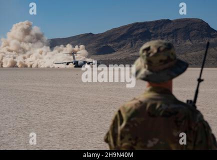 U.S. Air Force Maj. Tory Lodmell, quick response assessment team lead from to the 821st Contingency Response Squadron, Travis Air Force Base, Calif., clears a C-17 Globemaster III for take-off from Delamar Dry Lake, Nevada, during U.S. Air Force Weapons School Integration at Nellis Air Force Base, Nevada, Dec. 4, 2021. The 821st CRS partnered with the U.S. Air Force Weapons School to conduct ‘Alpha Mike’ training, which is a quick response assessment team of eight Airmen that deploy to quickly assess the suitability of airfields during contingency operations. (U.S. Air Force photo by Airman 1s Stock Photo