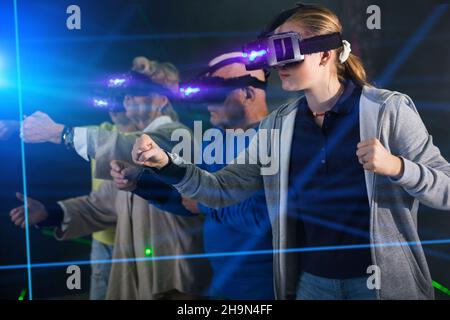 Girl in VR headset playing games with his family Stock Photo