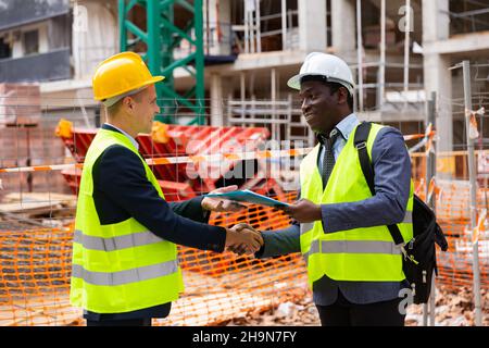 Two engineers concluding agreement and shaking hands Stock Photo