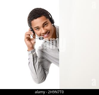 African-American technical support agent with blank poster on white background Stock Photo