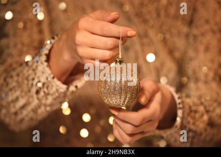 Woman holding golden Christmas ball, closeup Stock Photo