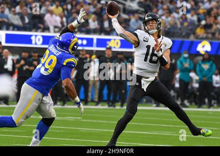 Los Angeles Rams defensive end Aaron Donald (99) looks up at the NFC  Championship trophy as Rams quarterback Jared Goff (16) lifts it in the air  after beating the New Orleans Saints