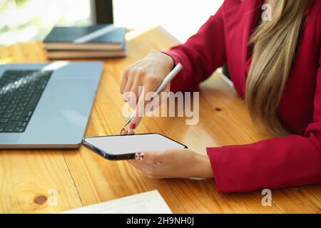 Close-up image of an asian young businesswoman using her modern smartphone at her desk in the office Stock Photo
