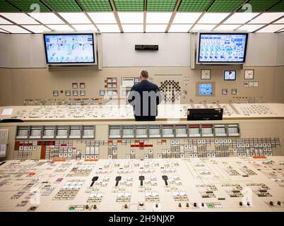 02 December 2021, Schleswig-Holstein, Brokdorf: An employee stands at a control panel in the control room of the Brokdorf nuclear power plant. After almost 35 years of operation, the nuclear power plant operated by Preussen Elektra will be shut down at the end of 2021. The pressurised water reactor with an output of around 1400 megawatts has been supplying electricity since 1986. Photo: Christian Charisius/dpa Stock Photo
