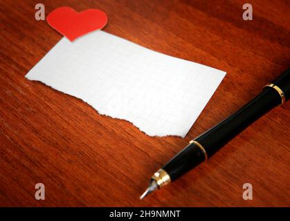 Blank Writing Pad with Heart Shapes and Pen on The Table Stock Photo