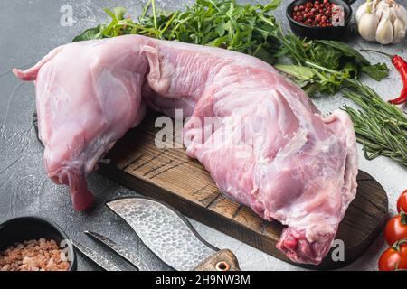 Raw and fresh meat. Whole rabbit ready to cook with ingredients set, on gray stone background Stock Photo