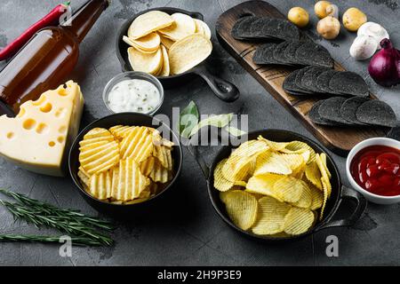 Potato chips. Beer snacks, sauce set with Cheese and Onion, with dipping sauces, on gray stone background Stock Photo