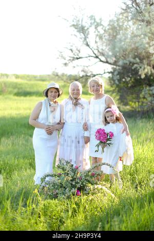 Caucasian happy grandmother standing with daughters and granddaughter outside. Stock Photo