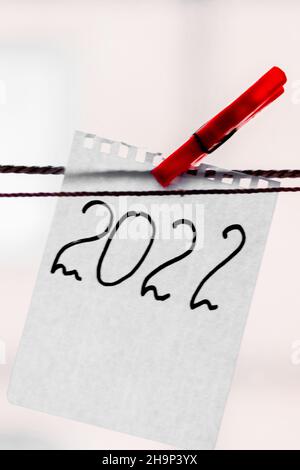 The number 2022 is written on a scrap of notepad. New year 2022. Stock Photo