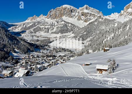 Empty ski slopes near the mountain village of La Villa in front of the snow-covered Dolomite peaks, Alta Badia ski area, Dolomites, South Tyrol, Italy Stock Photo