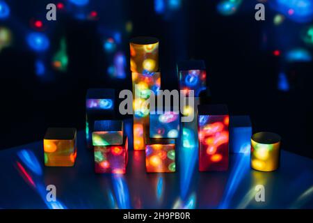 Metaverse, future, digital technology concept. Wooden constructor blocks on abstract multicolored neon lights background. Stock Photo