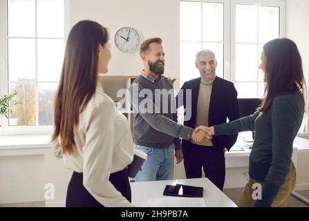 Happy, smiling business people meeting, making an acquaintance and shaking hands Stock Photo