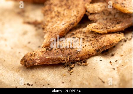 thinly sliced homemade lard with pepper on white oiled paper, close-up, selective focus Stock Photo