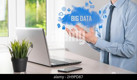 Businessman holds the inscription , word BIG DATA. Padlock , brain ,man, planet,graph, magnifier, gears, cloud, grid, document, letter, phone icon Stock Photo