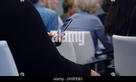 Businessman using their smartphone in the office. Young businessman typing text on the phone's workshop. Stock Photo