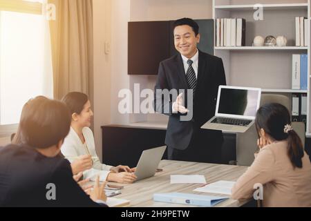 professional adult sale agent standing presentation on meeting room show laptop computer happy smile Stock Photo