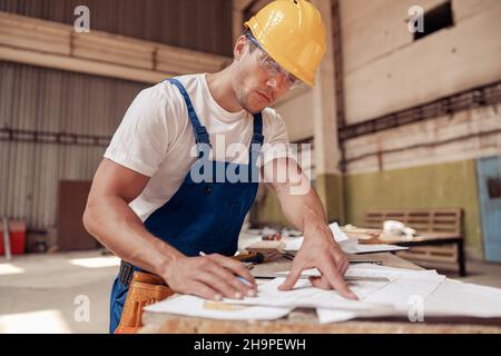 Handsome man architect drawing architectural building plan Stock Photo