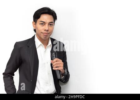 Portrait Asian male singer super star or presenter standing confident smile handle microphone isolated on white studio Stock Photo