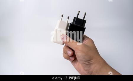 This is a black and white smartphone charger on a white background. It has a rectangular shape with rounded corners and a rounded back. Stock Photo