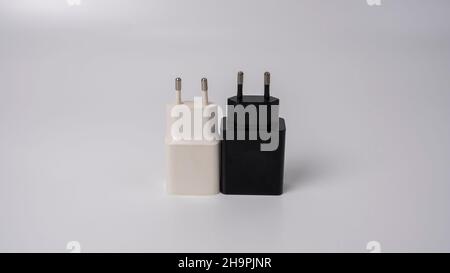 This is a black and white smartphone charger on a white background. It has a rectangular shape with rounded corners and a rounded back. Stock Photo
