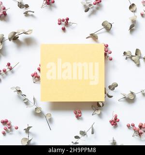 Yellow memo paper and floral pattern on white background. flat lay, top view, copy space Stock Photo