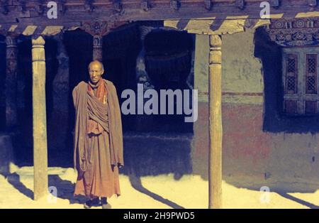 Buddhist monk in front of monastery in Tikse, 1974, Buddhism, monastic life, faith, monastery walls, single, alone, Buddhist monastery, monk's robe Stock Photo
