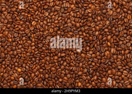 full frame background and texture of roasted coffee beans on flat wooden surface Stock Photo