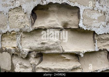 Fragment of wall with dilapidated limestone building blocks. Destructive effect of the atmosphere on sawn lime bricks. Close-up. Selective focus. Stock Photo