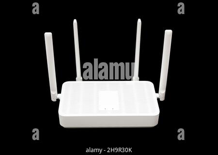 Modern WiFi 6 router with four antennas isolated on black background. Stock Photo
