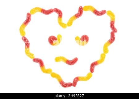 Anthropomorphic heart shaped face symbol made from gummy worms isolated on white background Stock Photo