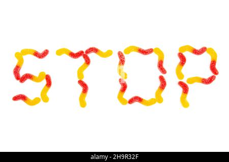 Word STOP made from multicolored gummy worms isolated on white background. Dental problems from chewy candies. Stock Photo