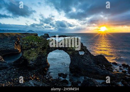 Gatklettur at sunrise, rock arch in the sea, Arnarstapi, Snaefellsnes Peninsula, West Iceland, Iceland Stock Photo