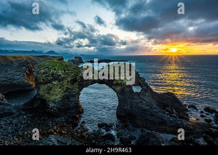 Gatklettur at sunrise, rock arch in the sea, Arnarstapi, Snaefellsnes Peninsula, West Iceland, Iceland Stock Photo