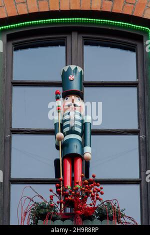 Large nutcracker soldier outside a window. Seasonal toy figure used as a festive Christmas decoration outdoors. Stock Photo