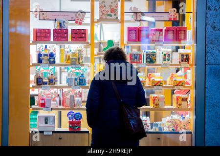 Berlin, Germany. 06th Dec, 2021. A woman looks at a shop window on a Berlin shopping street. Credit: Christoph Soeder/dpa/Alamy Live News Stock Photo