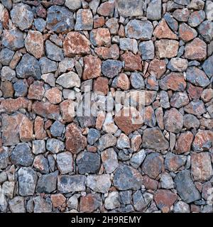 Seamless texture of masonry stone wall made of natural multicolored stone of various sizes.  Stock Photo