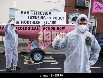 Extinction Rebellion activists Oscar Mooney (right), from Sandymount, and Art O’Laoghaire, from Bray, as they held a demonstration outside Sinn Fein’s headquarters in Dublin calling on the party to act now in the Northern Irish Executive to ensure a full and final ban on petroleum licensing. Picture date: Wednesday December 8, 2021. Stock Photo