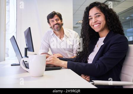 Two business people study together at the computer in the IT workshop in the office Stock Photo