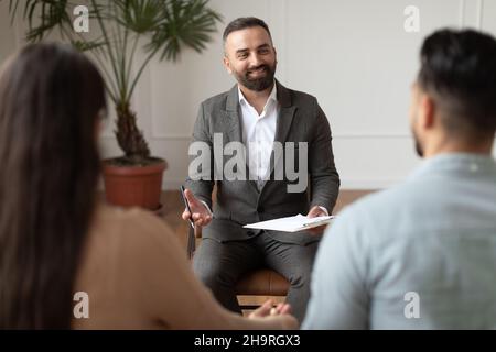 Young couple sitting at therapy session with therapist Stock Photo