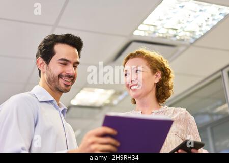 Young business people with clipboard and smartphone work together as trainees Stock Photo