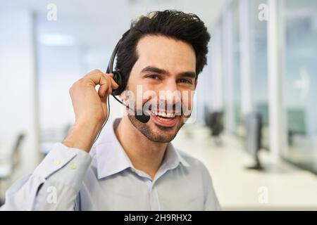 Young businessman as a customer service representative with headset talking to a customer Stock Photo