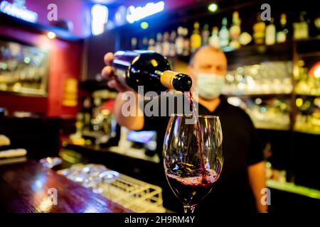 Berlin, Germany. 06th Dec, 2021. A pub owner pours a wine in a Berlin restaurant. Credit: Christoph Soeder/dpa/Alamy Live News Stock Photo