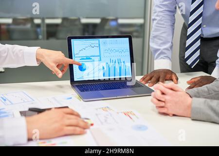 Business man pointing to diagram on laptop computer while doing financial analysis Stock Photo