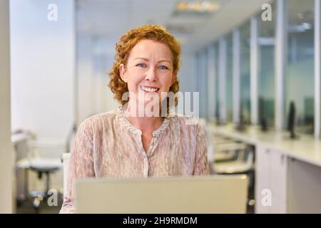 Successful young businesswoman working on computer in office Stock Photo