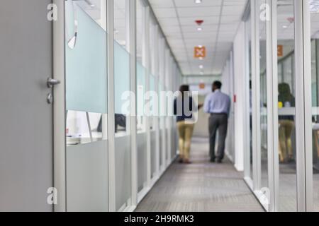 Two business people as colleagues talking to each other in the hallway in the office Stock Photo